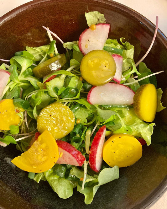 Fed Up Foods Curried Pickled Zucchini on a salad with radishes and green onions a perfect spring salad